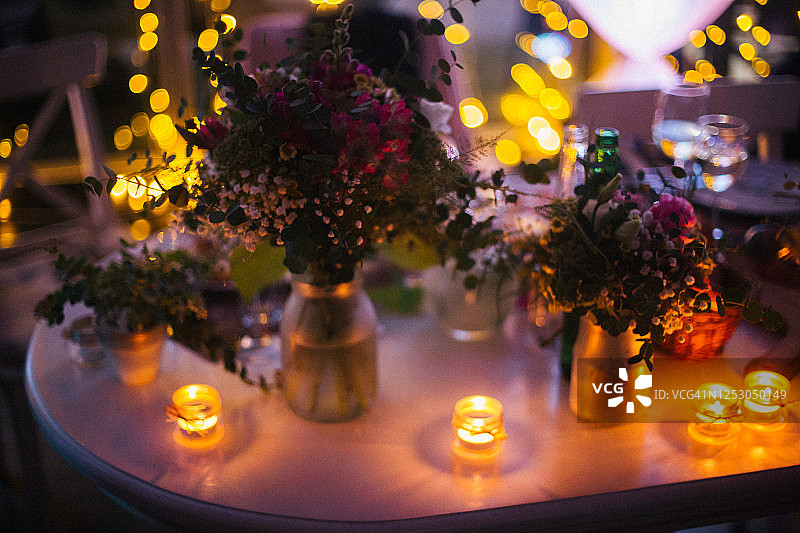 婚礼餐桌装饰与鲜花在罐子和蜡烛图片素材