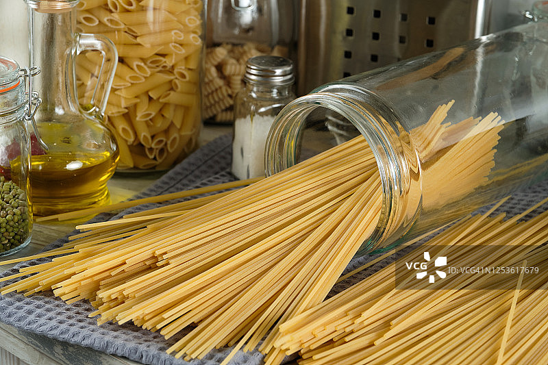 烹饪意大利面食。生的意大利通心粉放在玻璃罐中储存。素食和纯素食品。图片素材