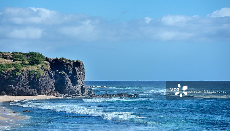 阳光明媚的留尼汪岛海滩和悬崖图片素材