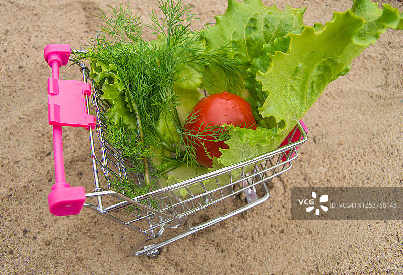 购物车里有蔬菜-西红柿，生菜，黄沙上的莳萝，饮食概念，顶视图，阳光图片素材
