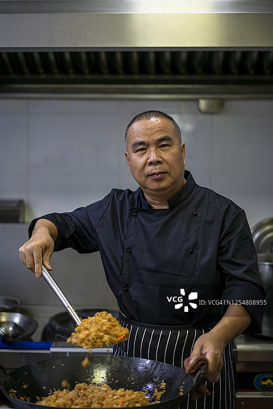 一个亚洲中年男性厨师在厨房工作图片素材