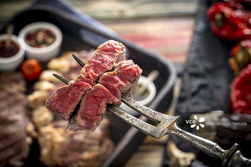 切肉牛肉条牛排肉宏与复古切肉叉和酱汁图片素材