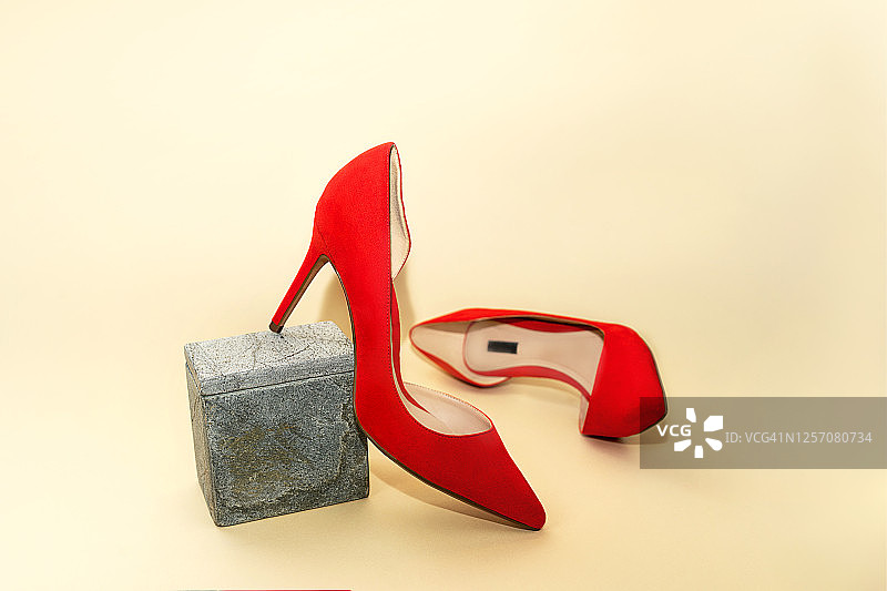 女性时尚奢侈装红色鞋米色背景。图片素材