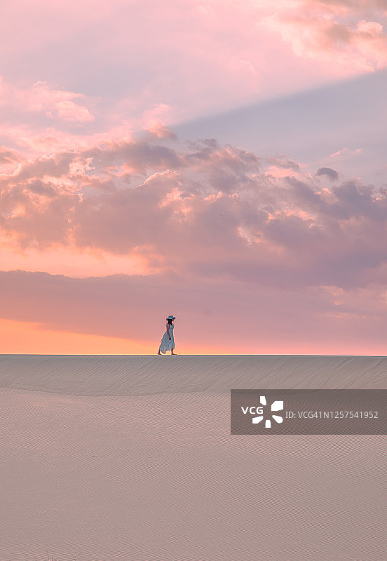 一名年轻女子在土耳其安塔利亚帕塔拉的沙丘上欣赏日落图片素材