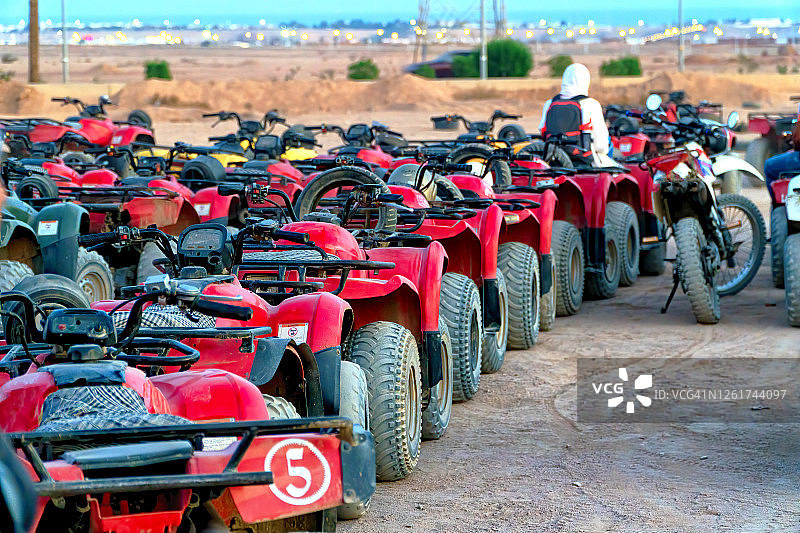 一排红色的全地形车辆准备在埃及撒哈拉沙漠的沙丘进行新的冒险图片素材