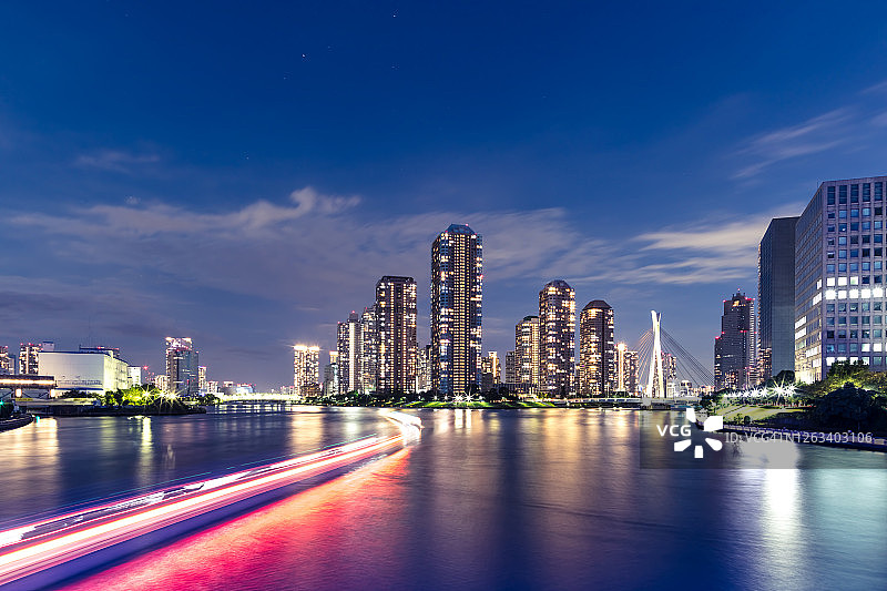东京天际线美丽的滨水夜景，船屋灯光的踪迹，在隅田河，日本，东京。图片素材