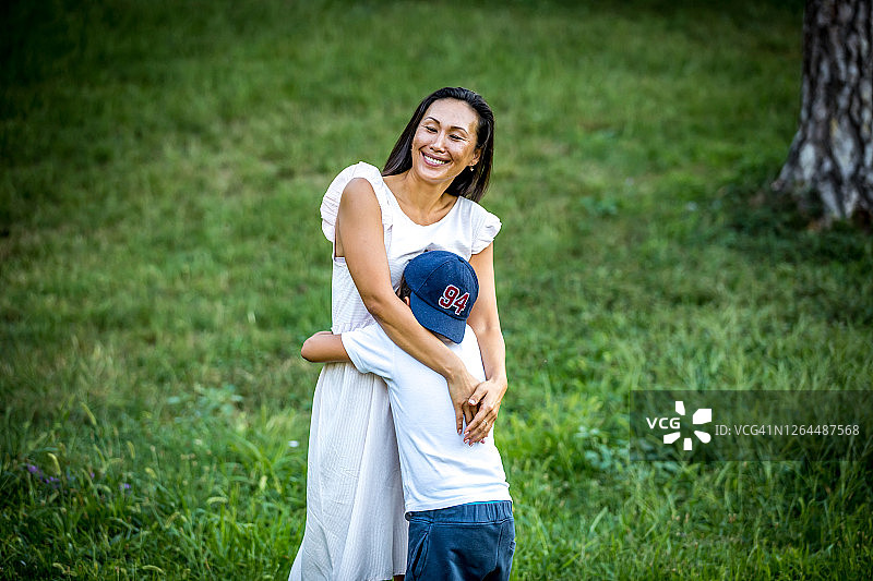 一个快乐的母亲和儿子在户外微笑的肖像图片素材