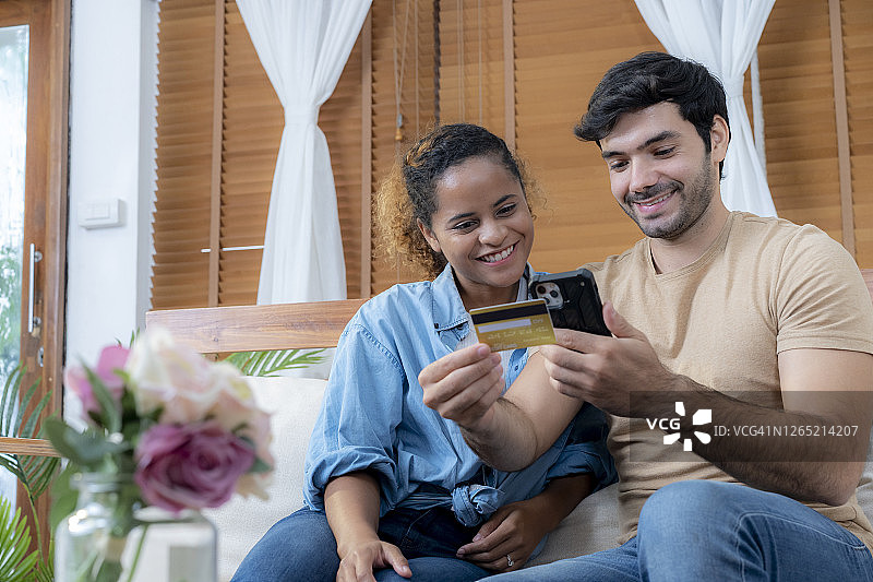 年轻夫妇在家用信用卡网购图片素材