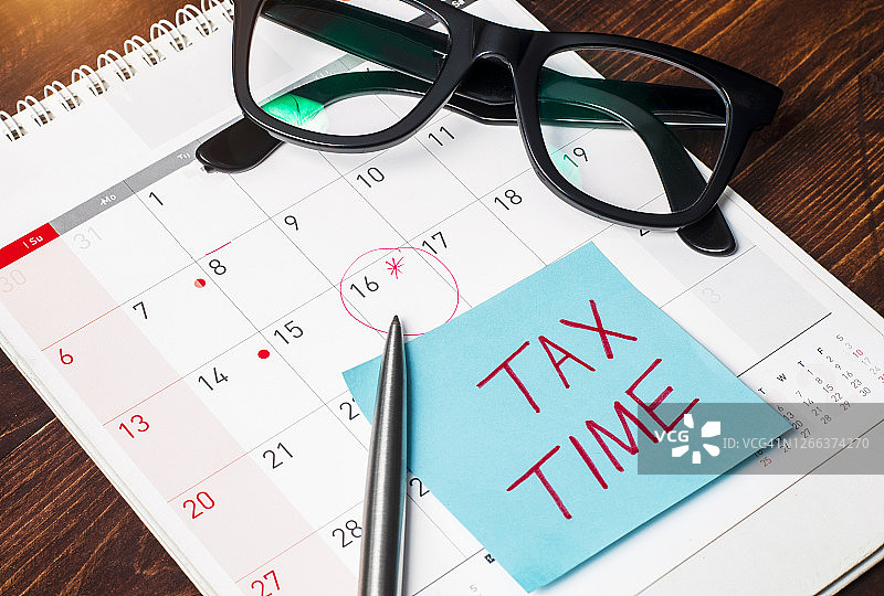 税务时间写在纸上，贴在日历页上，关于税务时间提醒的想法和概念图片素材