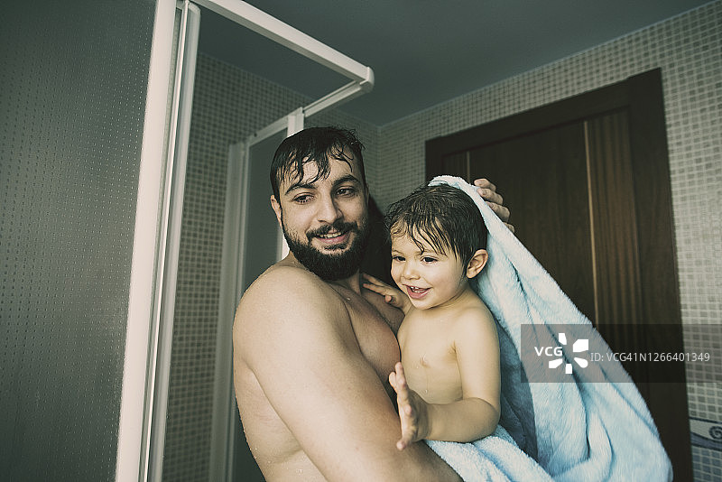 35岁的父亲和1岁的儿子在一个家庭场景中洗澡图片素材