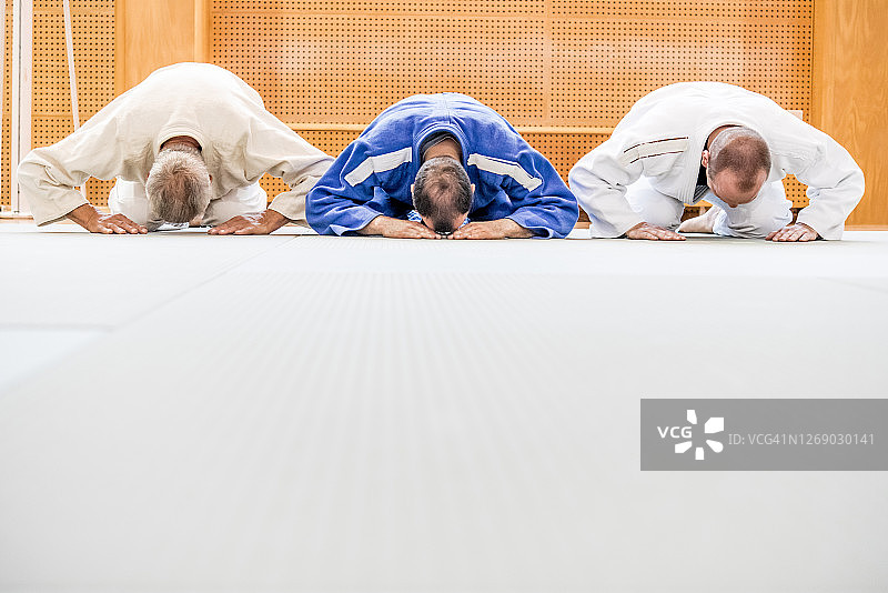 三个柔道运动员跪在地上图片素材