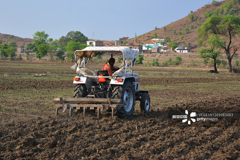印度中央邦提坎加尔——2020年6月15日:印度农民用拖拉机准备用耙子播种。图片素材