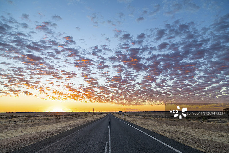漫长的乡村公路在干旱，干旱地区的澳大利亚与美丽的日出颜色的天空图片素材