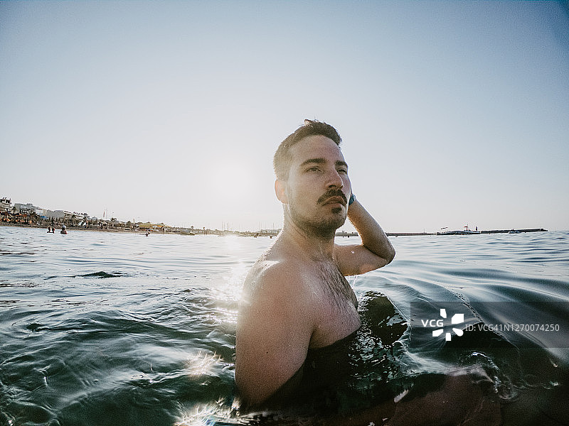 一个年轻人在海里游泳的肖像图片素材