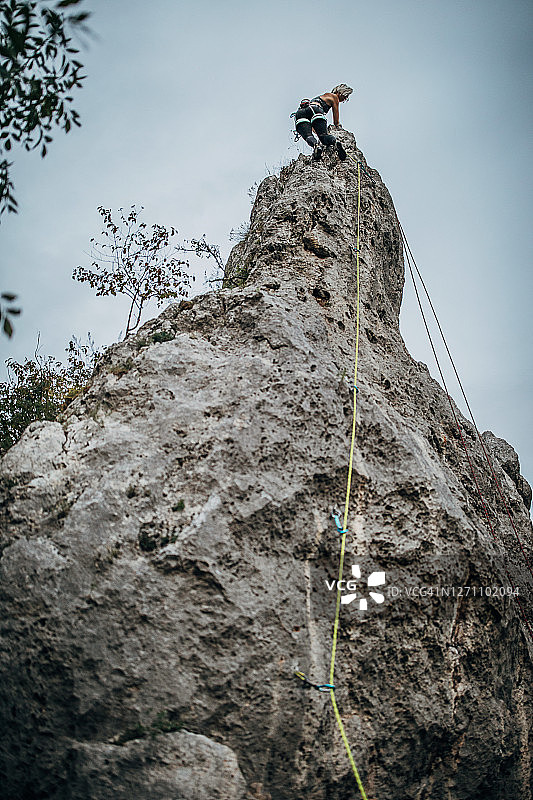 从山上爬下来的运动型女性攀岩者图片素材
