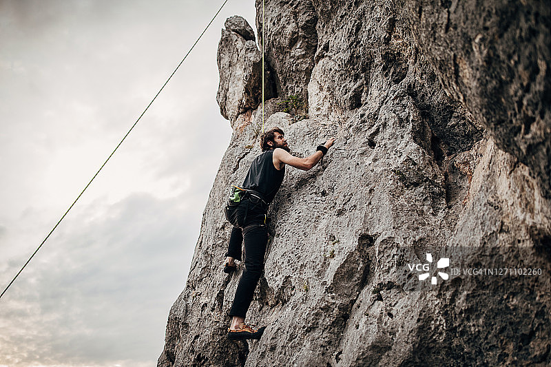 运动的男性自由攀登者在岩石上攀登图片素材