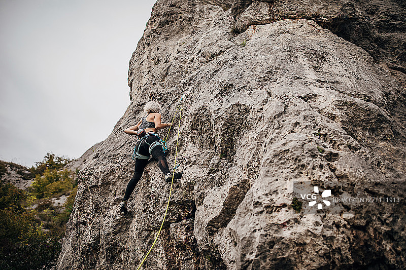 一位女性极限攀登者正在爬山图片素材