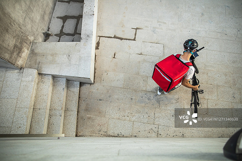 在城市里骑自行车送食物的人图片素材