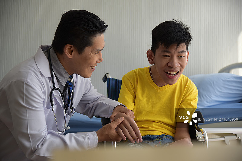 医生照顾一个坐在轮椅上的残疾男孩图片素材