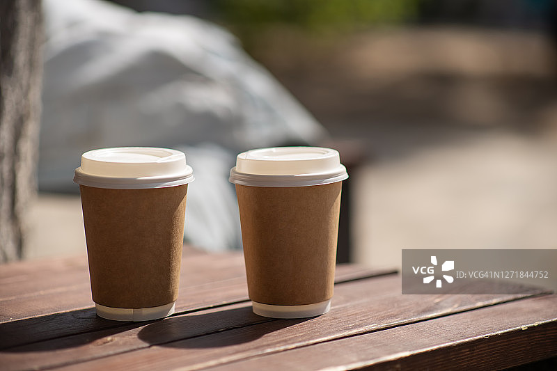 以咖啡开始新的一天。两杯拿铁在奶油模糊的背景上。图片素材