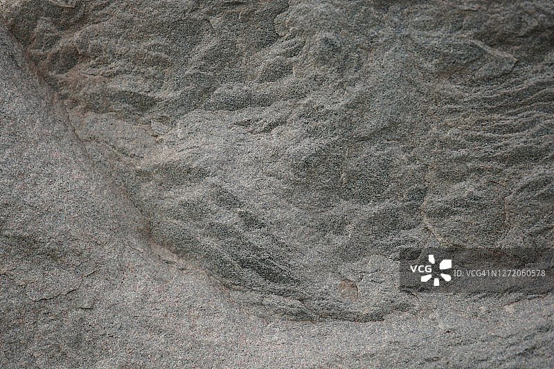 灰棕色的石头背景。岩石纹理。花岗岩山体表面纹理。宏。图片素材