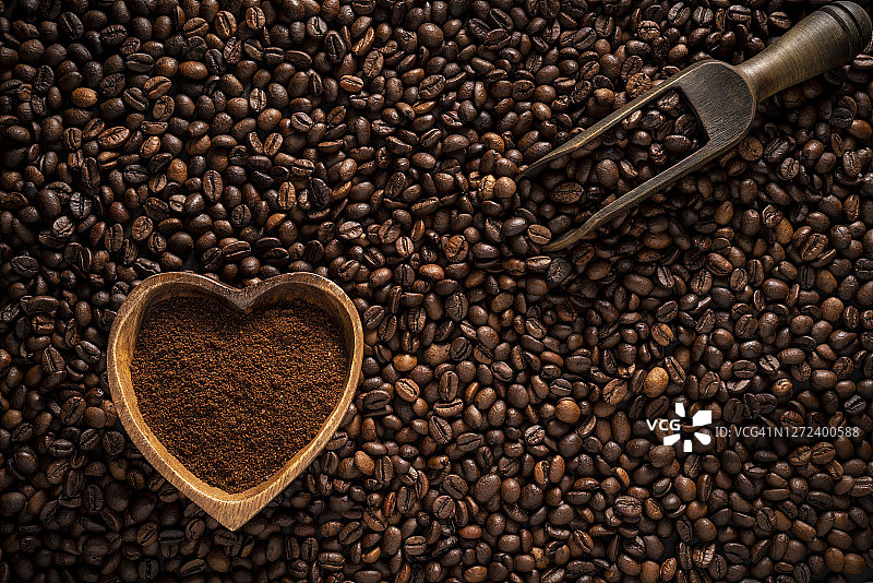 以咖啡豆为背景，心型碗，配上咖啡粉图片素材