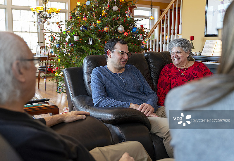 圣诞节全家团聚。两代人围坐在宽敞的客厅的咖啡桌上图片素材