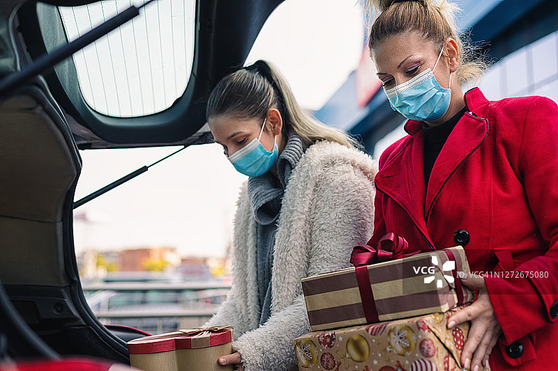 2019冠状病毒病大流行期间，家庭购买圣诞礼物。他们戴着防护口罩，以防止冠状病毒感染。图片素材