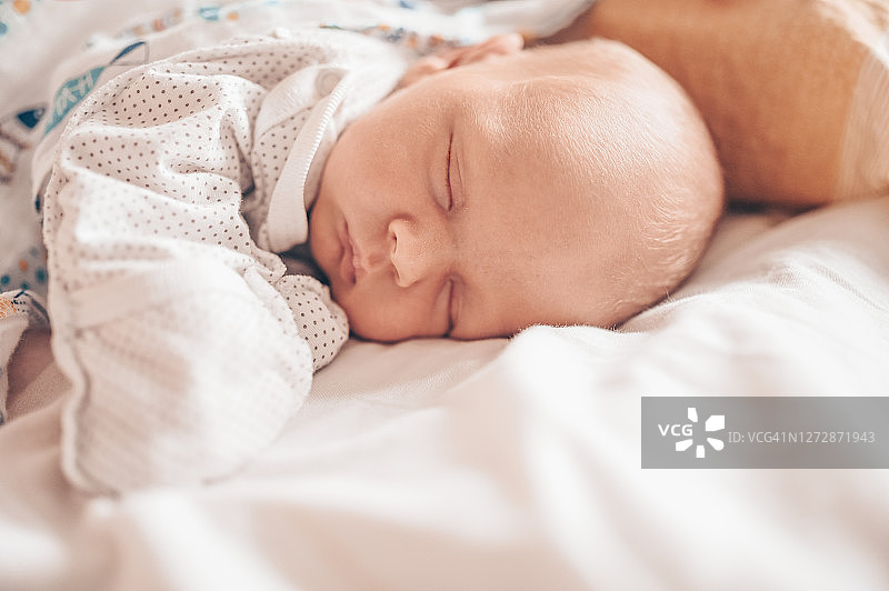 可爱的情感新生有趣的小男孩睡在婴儿床。婴儿用品包装模板。健康儿童、医院概念和幸福母亲。婴儿的婴儿。托儿所图片素材