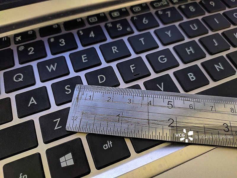 手提电脑键盘上方的铁尺图片素材