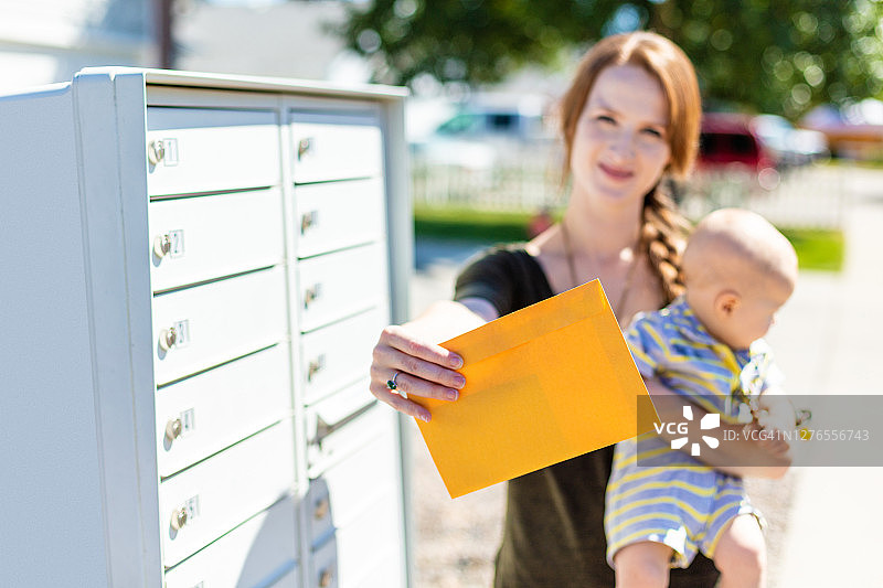 美国西部年轻母亲与婴儿与邮寄选举选票和邮箱照片系列图片素材
