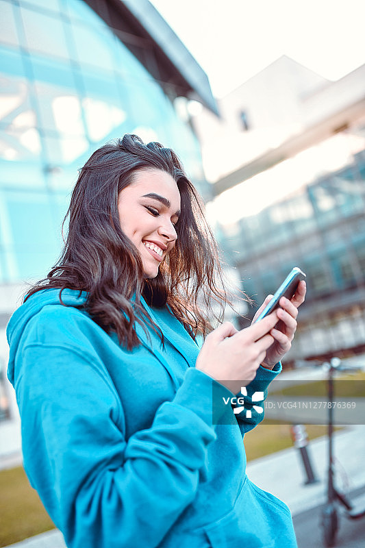 女性美容用智能手机在外面发短信图片素材