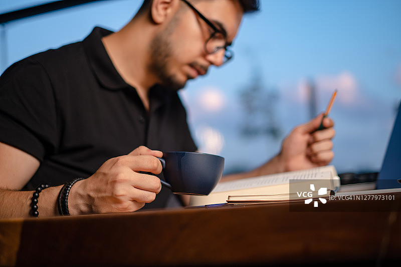 年轻人一边喝咖啡一边看书图片素材