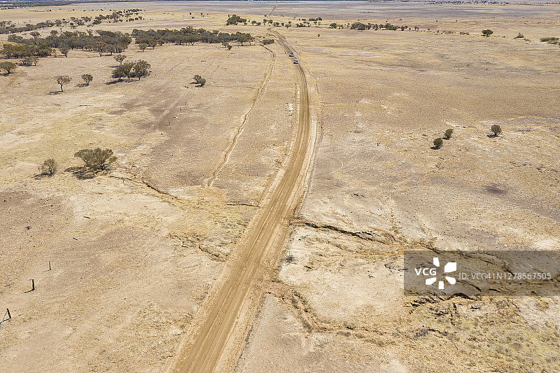 鸟瞰图，一条长长的铺着红土的道路，从干涸的河床，澳大利亚内陆图片素材