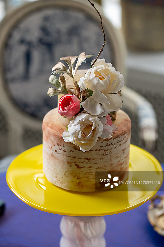 美丽的婚礼蛋糕装饰鲜花在桌子上。黄色和粉红色的蛋糕架。图片素材