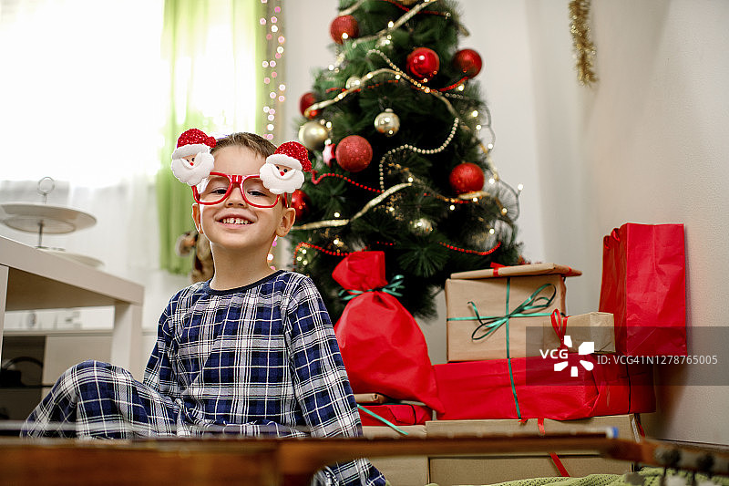 快乐的小男孩圣诞节在家弹吉他图片素材