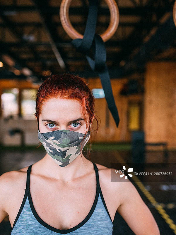 新冠肺炎期间，一名妇女在健身房使用口罩的肖像图片素材