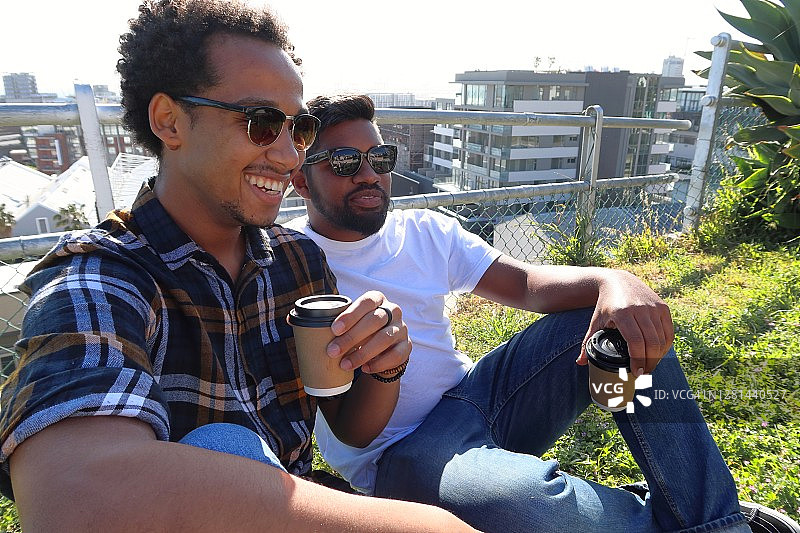 朋友们正在享受以城市为背景的咖啡休息图片素材