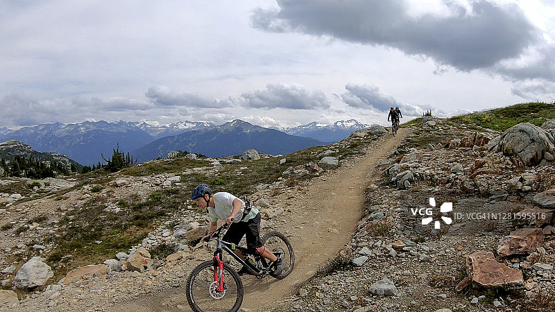 山地自行车手沿着高山小径骑行图片素材