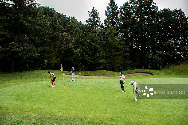 人们喜欢和朋友在草地上打高尔夫球图片素材