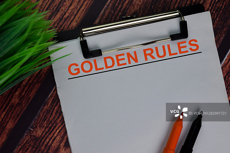 黄金法则的文本写在文件上，孤立地放在办公桌上。图片素材
