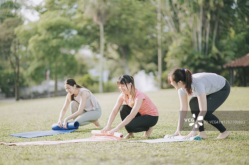 3个亚洲中国年轻女性在周末的早上在公园练习瑜伽图片素材