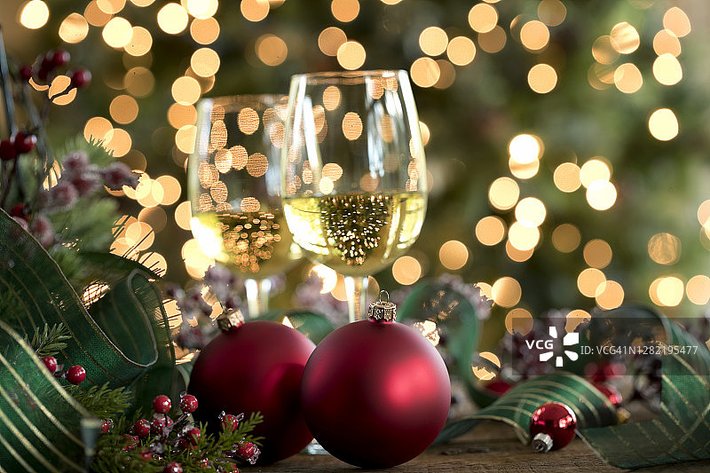 圣诞树前的圣诞白葡萄酒和红色装饰物图片素材
