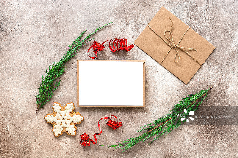 圣诞组成。空白卡片模型，冷杉树枝，信封里的信，姜饼雪花。圣诞贺卡模板。俯视图，平放。米色纹理grunge背景。图片素材