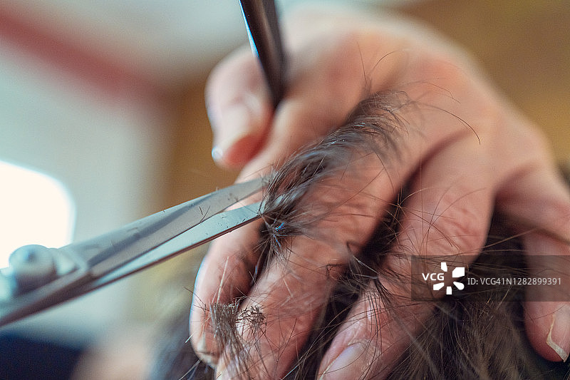 一个女人在禁闭期间在家剪她丈夫的头发图片素材