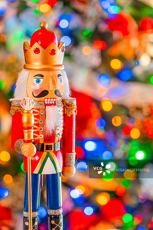 一个胡桃夹子国王，戴着珠宝皇冠和权杖，站在一棵柔软的圣诞树前。图片素材