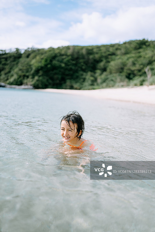 欢快的小女孩在清澈的热带水中嬉戏图片素材