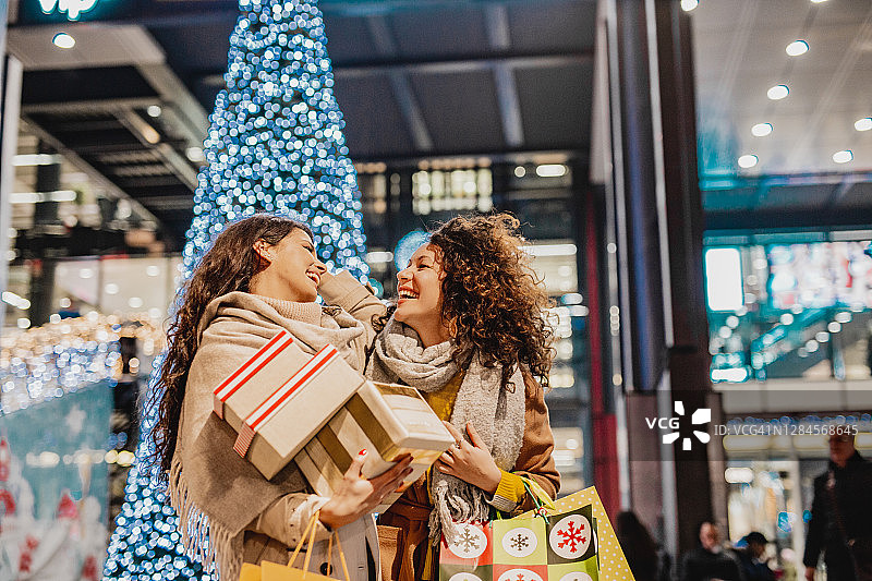 两个兴奋的女性朋友在假日购物图片素材