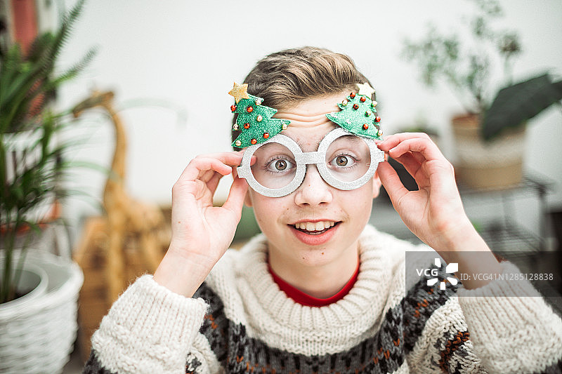 少年男子戴着愚蠢的圣诞眼镜的肖像图片素材
