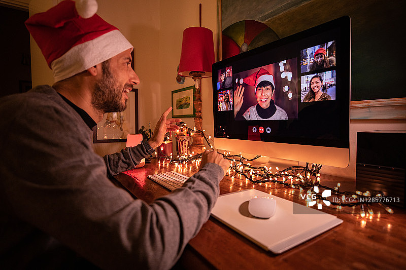 圣诞期间，男人在电脑前与亲朋好友视频通话图片素材